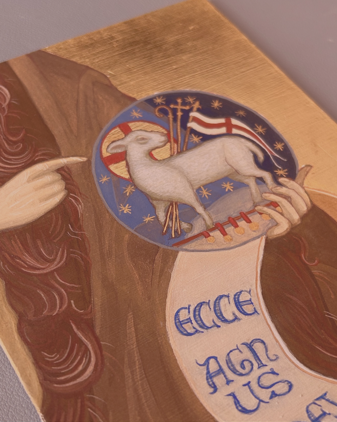 Decorative illustration with a lamb, cross, and text on a gold background