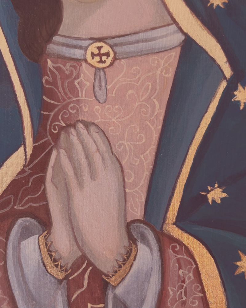 Close up of Our Lady of Guadalupe painting featuring her Veil, Dress, Necklace, and hands folded in prayer