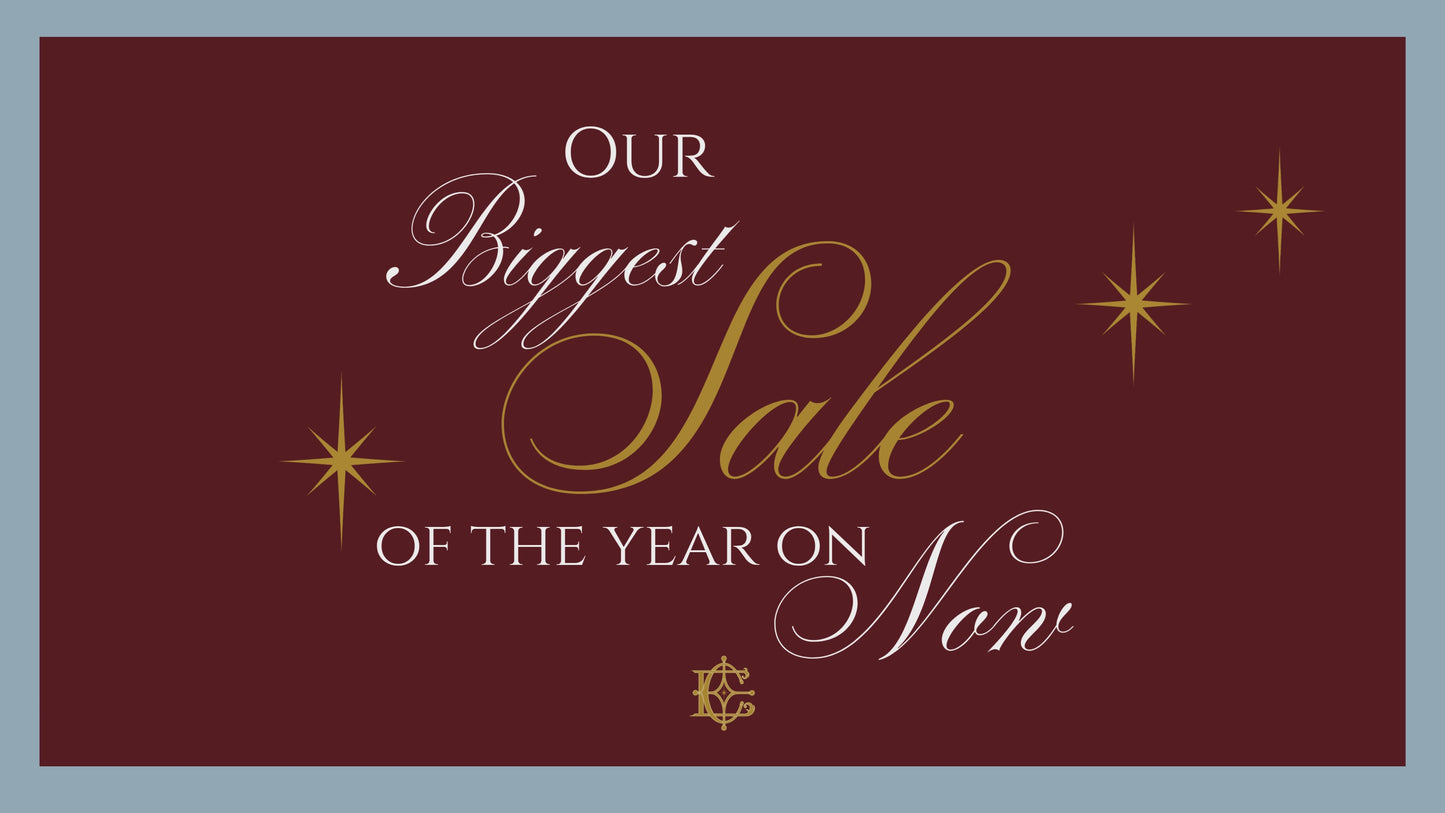 "Our biggest sale of the year on now" in script with sparkling gold stars over burgundy and blue background